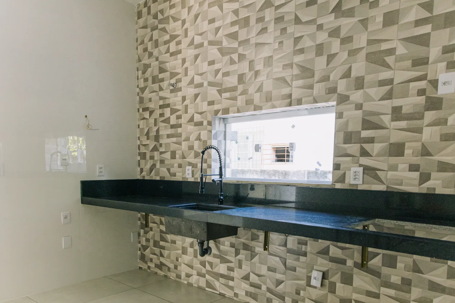 Cozinha reformada com parede texturizada e acabamento premium